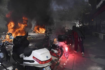 Un encapuchado con una bengala quema una moto en el centro de París, el pasado mes de abril. 