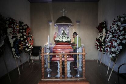 Un hombre junto al ataúd de Armando Pérez Luna, candidato panista asesinado en Michoacán.