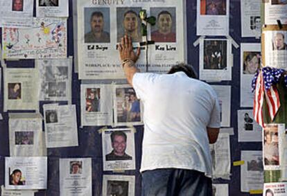 Un hombre se lamenta en el muro exterior del Hospital Bellevue de Nueva York, repleto de fotografías de desaparecidos.