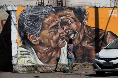 Com esta obra, Pato queria transmitir amor para as pessoas que passam pela rua. Na foto, uma mulher com carrinho de compras fala e gesticula em frente à pintura, como se estivesse conversando com o casal retratado. "Muitas pessoas se sentem identificadas", explica Pato.