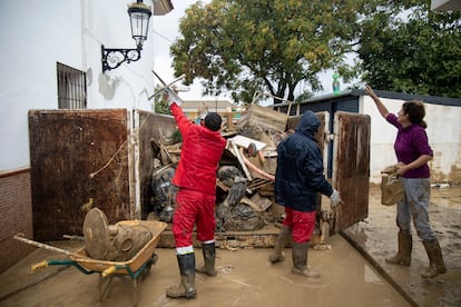 Vecinos limpian las calles y las casas de barro de la Barriada Doña Ana de la localidad de Cartama, en Málaga, este miércoles.