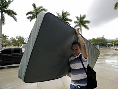 Uno de los evacuados desplaza un colchón para refugiarse en la Universidad de Miami.