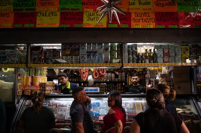 Personas hacen fila para comprar en una tienda de Caracas. 