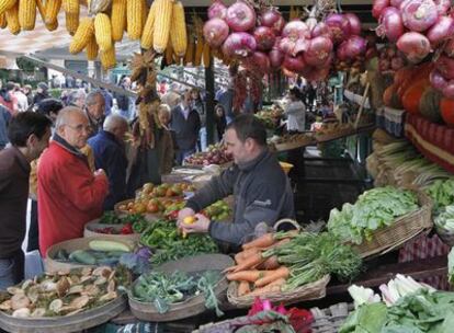 Un productor de hortalizas atiende a varios clientes ayer en la feria de Gernika.