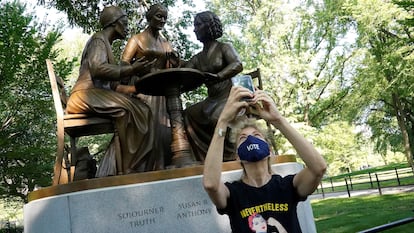 Una mujer se hace una foto frente a una estatua que honra los derechos de la mujer, entre ellos el derecho al voto, en Central Park.