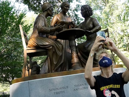 Una mujer se hace una foto frente a una estatua que honra los derechos de la mujer, entre ellos el derecho al voto, en Central Park.