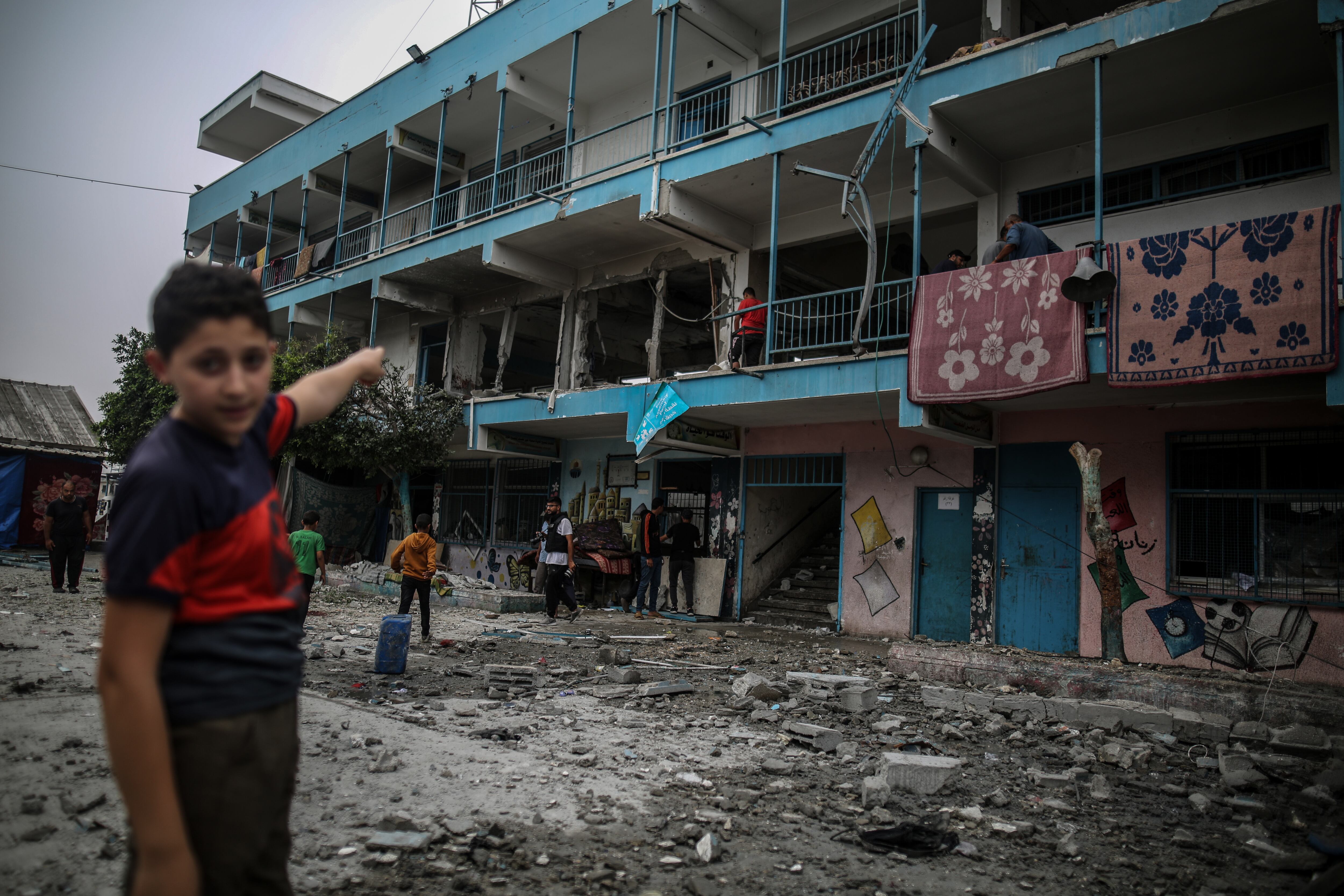 Un niño palestino muestra las paredes dañadas de la escuela de la UNRWA tras bombardeos del ejército israelí, en el campo de refugiados de Nuseirat (Franja de Gaza) que alberga a miles de personas desplazadas, este 6 de junio.