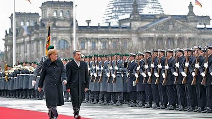 El presidente colombiano, Álvaro Uribe, junto a la canciller alemana, Ángela Merkel, pasan revista a la guardia de honor ante la sede de la cancillería en Berlín