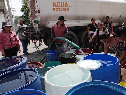 Vecinos de la alcaldía Iztapalapa, llenan botes y tambos que son suministrados por pipas de agua, en una imagen de archivo.