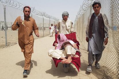 Ciudadanos afganos trasladan a un pariente enfermo en la frontera entre Pakistán y Afganistán, en Chaman.