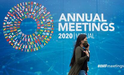 Una mujer camina ante el cartel que anuncia la reunión anual del FMI en Washington el martes.