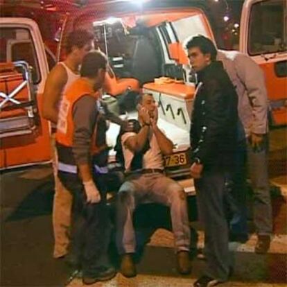 Una imagen de televisión muestra a un hombre herido en la explosión siendo atendido por los servicios médicos israelíes.