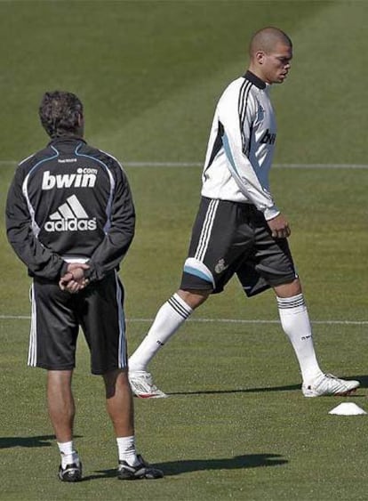 El técnico del Real Madrid, Juande Ramos, de espaldas mientras Pepe camina sobre el césped de Valdebebas.