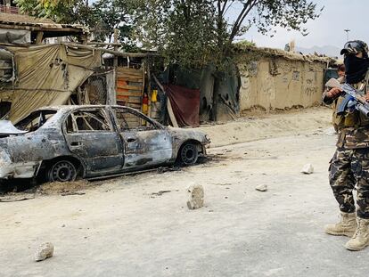 Un militar frente a un coche destruido por EE UU en Kabul (Afganistán).
