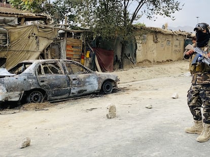 Un militar frente a un coche destruido por EE UU en Kabul (Afganistán).