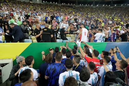 Jugadores de Argentina intentan controlar los disturbios entre hinchas de Brasil y de Argentina.
