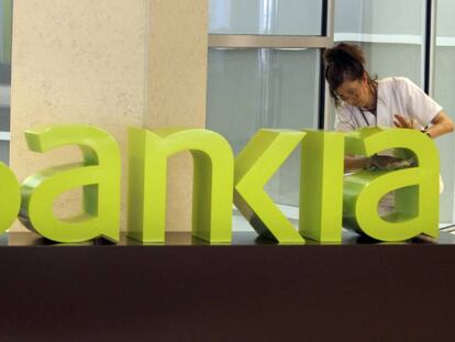 Una operaria limpia el logo de Bankia, en una imagen de archivo.