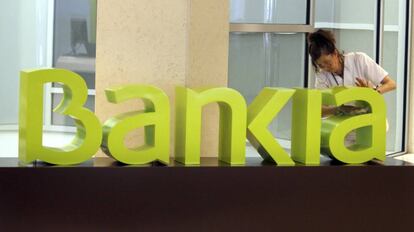 Una operaria limpia el logo de Bankia, en una imagen de archivo.