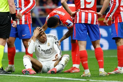 El delantero francés del Real Madrid, Kylian Mbappé se duele en el suelo, rodeado de contrarios.