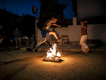 Un niño saltando la hoguera de la noche del 23 de junio en la colonia del Manzanares.