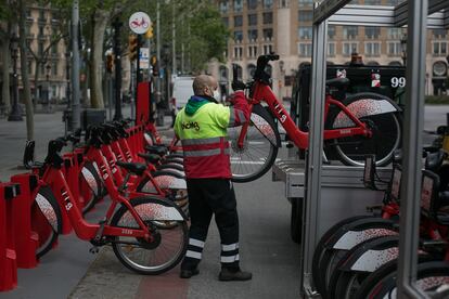 Un operario coloca bicicletas del Bicing el primer día de retomar la actividad durante la crisis del coronavirus.