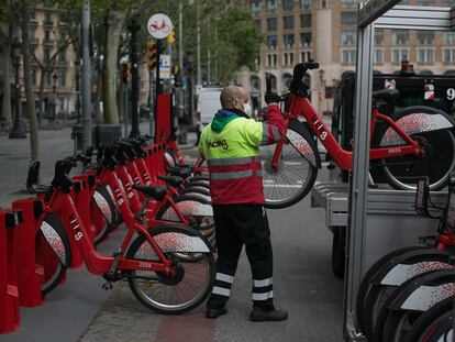 Un operario coloca bicicletas del Bicing el primer día de retomar la actividad durante la crisis del coronavirus.