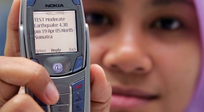 Una mujer muestra un SMS del centro de monitoreo de tsunamis en Kuala Lumpur, en 2005.