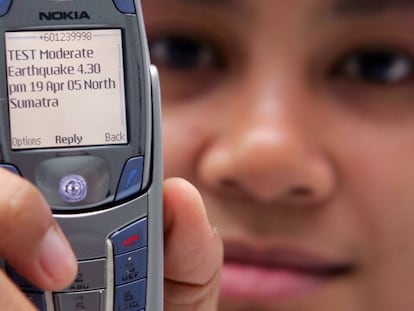 Una mujer muestra un SMS del centro de monitoreo de tsunamis en Kuala Lumpur, en 2005.