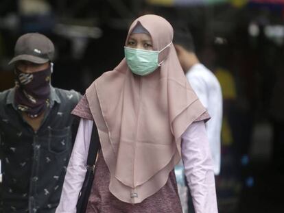Residentes de Jakarta, Indonesia, pasean portando máscaras protectoras ante el miedo al coronavirus en una imagen tomada hoy.