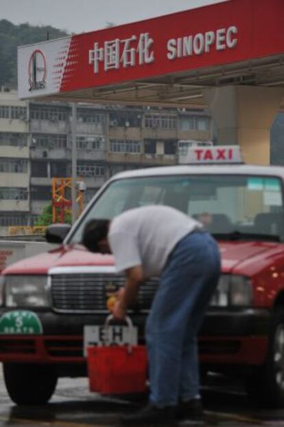 Un taxista lava su coche en una gasolinera de Sinopec en Hong Kong.