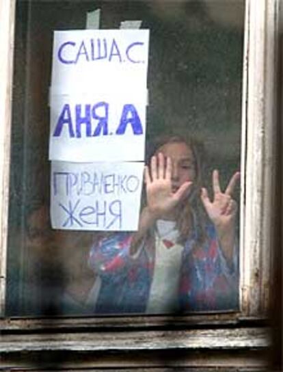 Una superUna superviviente se comunica con sus familiares a través de la ventana de un hospital.viviente se comunica con sus familiares a través de la ventana de un hospital.