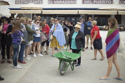 Un grupo de turistas recién llegados al puerto de la Caleta del Sebo, miran y fotograf’an a una de las vecinas de la localidad.
