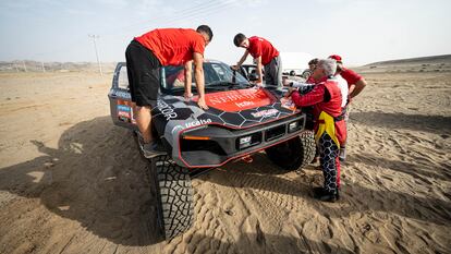 Manolo Plaza observa a dos alumnos de la Universidad de Nebrija trabajando sobre el coche cerca del campamento del mar en Yanbu, Arabia Saudí.