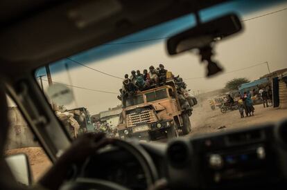 Un grupo de migrantes en la parte superior de una camioneta atraviesa el desierto de Níger en dirección Libia.