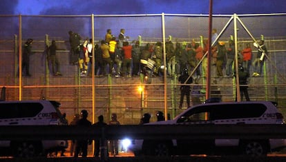 A group of migrants attempting to jump the border fence in Melilla in October  2014.  