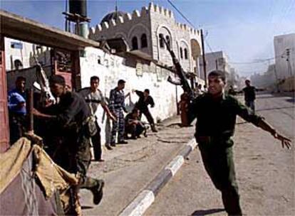 Policías palestinos corren para protegerse mientras su cuartel general es alcanzado por misiles, ayer en Gaza.