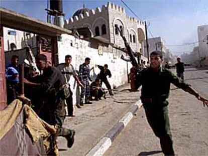 Policías palestinos corren para protegerse mientras su cuartel general es alcanzado por misiles, ayer en Gaza.