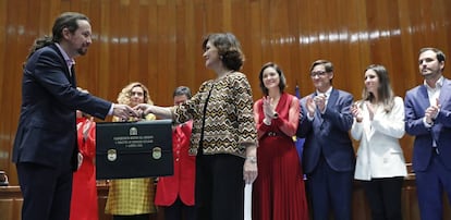 El nuevo Vicepresidente de Derechos Sociales y Agenda 2030, Pablo Iglesias (i) recibe su cartera de la vicepresidenta primera y ministra de Presidencia y Relaciones con las Cortes, Carmen Calvo (d) durante la toma de posesión en un acto celebrado en la sede del Ministerio de Sanidad, Consumo y Bienestar Social en Madrid.