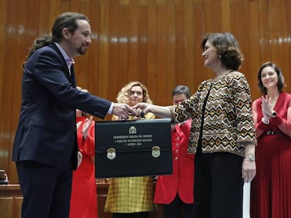 El nuevo Vicepresidente de Derechos Sociales y Agenda 2030, Pablo Iglesias (i) recibe su cartera de la vicepresidenta primera y ministra de Presidencia y Relaciones con las Cortes, Carmen Calvo (d) durante la toma de posesión en un acto celebrado en la sede del Ministerio de Sanidad, Consumo y Bienestar Social en Madrid.