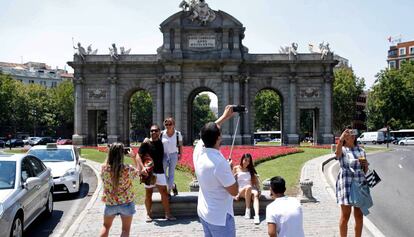 Turistas se fotografían en la madrileña Puerta de Alcalá.
