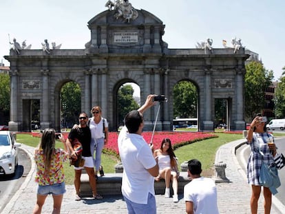 Turistas se fotografían en la madrileña Puerta de Alcalá. 