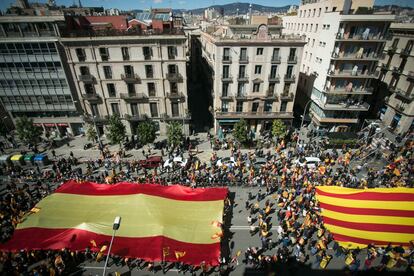 Manifestantes sostienen una gran bandera de España y Cataluña durante la manifestación.
