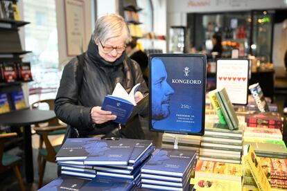 A woman reads a copy of 'Kongeord' (The Word of a King), the book written by Jens Andersen about King Frederick X, at a bookstore in Copenhagen on January 17, 2024. 