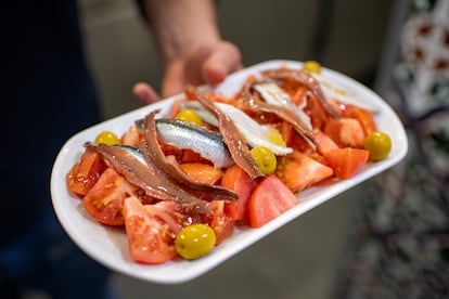 Ensalada de tomate partido con anchoas, boquerones y aceitunas, uno de los platos estrella del bar El Boquerón. 