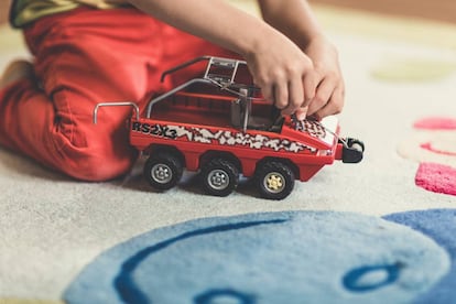 Un niño juega con su lancha de juguete en casa. 