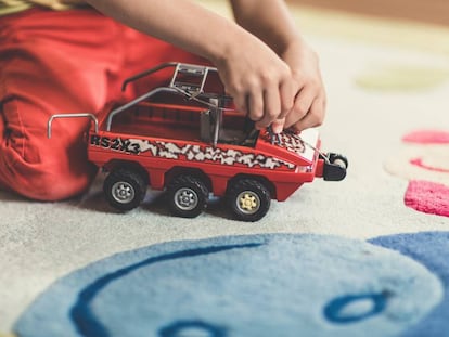 Un niño juega con su lancha de juguete en casa. 