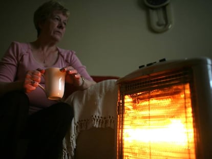 Una mujer, junto a una estufa eléctrica, en una imagen de archivo.