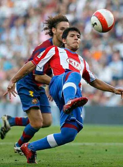 Agüero controla el balón ante Milito.