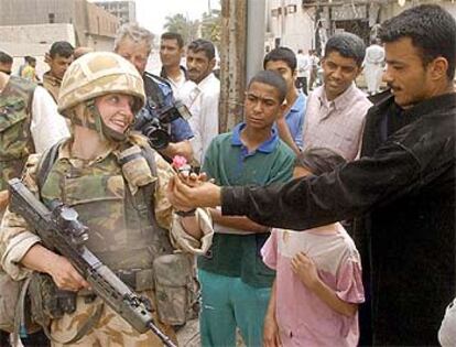 Sam Sheppard, una soldado británica de 28 años, sonríe en la ciudad de Basora al recibir una flor de un iraquí.