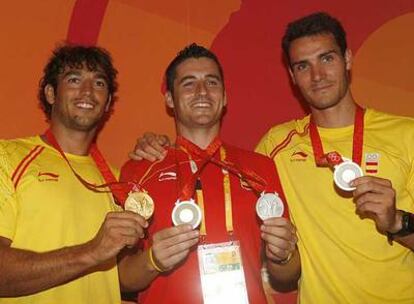 Los integrantes del K-2 (oro), Carlos Pérez, a la izquierda, y Saúl Craviotto flanquean a David Cal (plata en k-1) mostrando sus medallas.